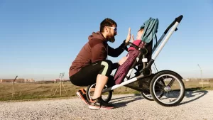 Roditeljstvo i trening - tata sa detetom u kolicima za trčanje